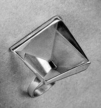 This photo taken by Margaret De Patta also included her handwritten description on a sheet attached to the photograph: "Flat topped crystal with four back facets converging on center facet (culet), which is parallel to top. Two facets polished, two frosted. Black enamel beneath tiny bottom plane (culet) gives effect of extended perspective."